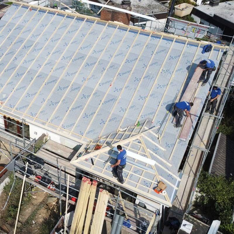 Dachdecker montieren die Konterlattung nach aufbringen der Dachdämmung bei einer Dachsanierung.