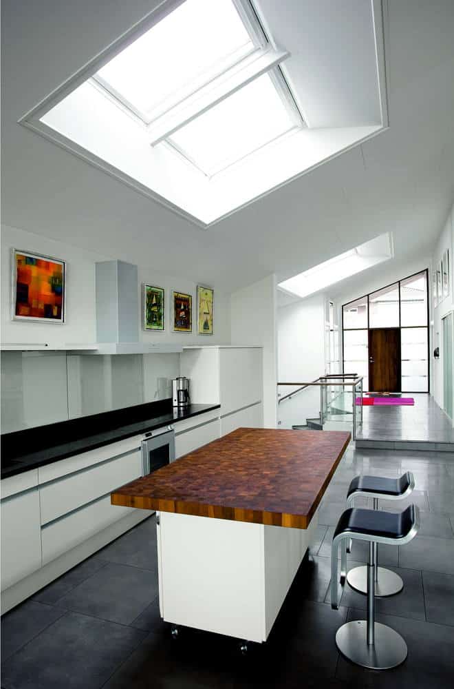 Moderne Küche unter dem Dach mit Dachfenstern erhellt.